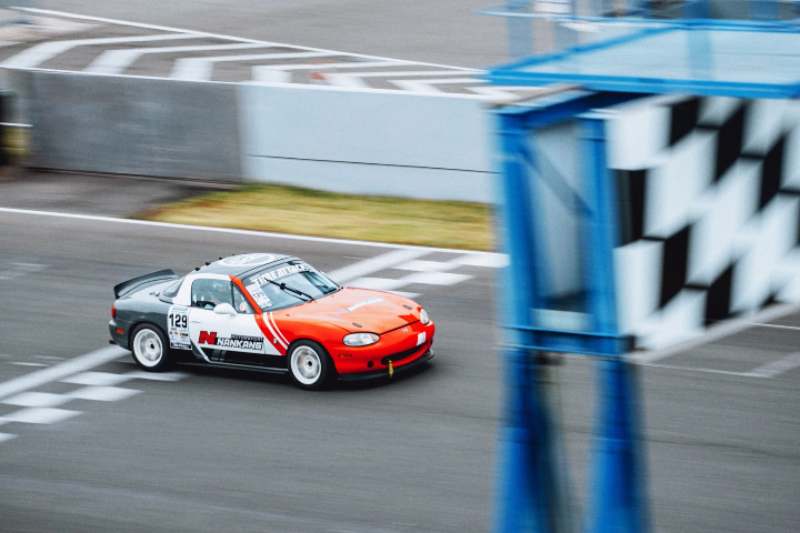 Red-and-white Mazda MX-5 in a fast panning shot