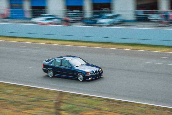 Blue BMW E36 coupe passing the pit wall