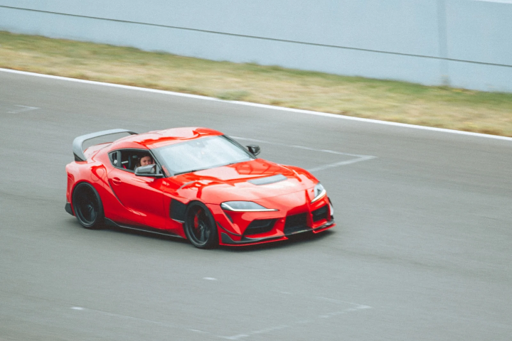 Red Toyota Supra with widebody kit on track