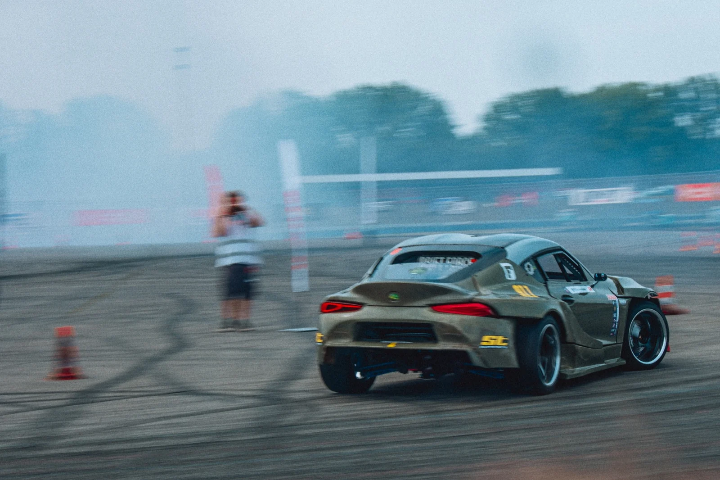 Bronze Toyota Supra drifting past a photographer