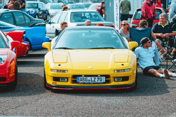 Yellow Honda NSX surrounded by spectators