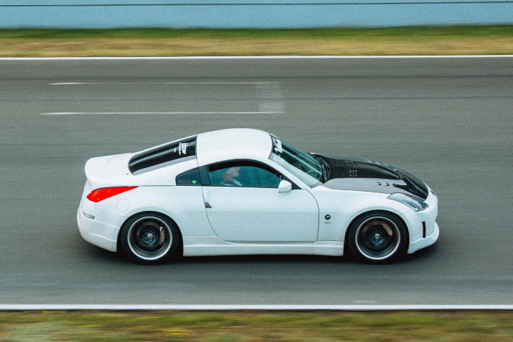 White Porsche 911 GTS in profile on the circuit