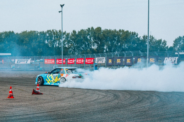 Blue drift car leaving a thick smoke trail