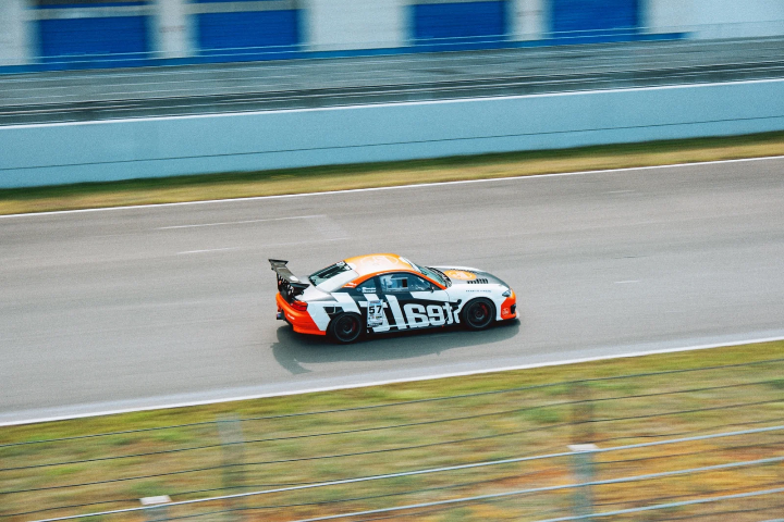 Orange-and-black race car accelerating down the straight