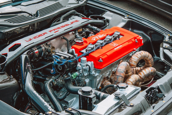 Honda VTEC engine bay — red valve cover and wrapped manifold