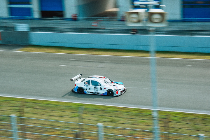 White-and-blue race car speeding down the straight