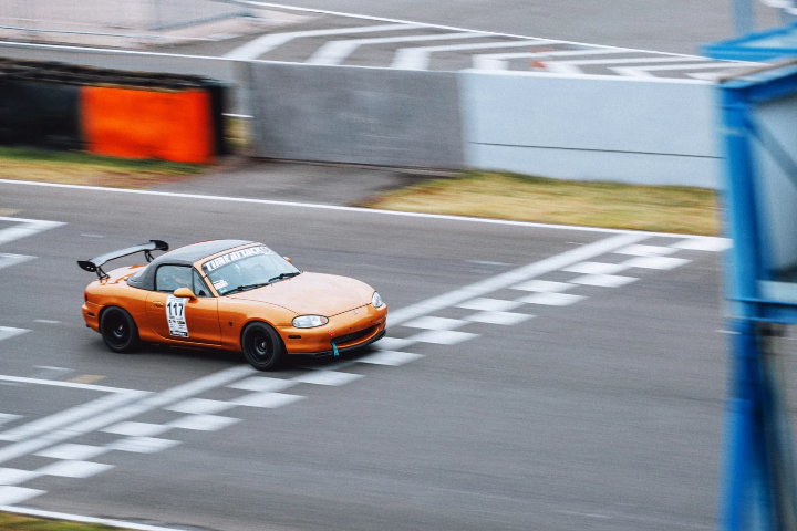 Orange Mazda MX-5 crossing the start line