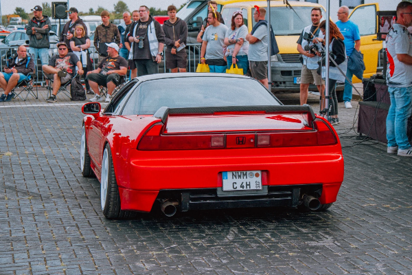 Red Honda NSX with a rear wing in the paddock