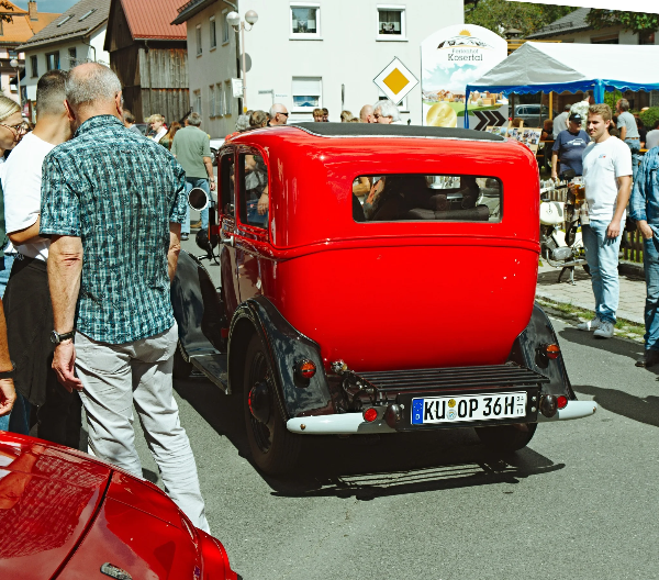Red 1930s sedan in the festival crowd