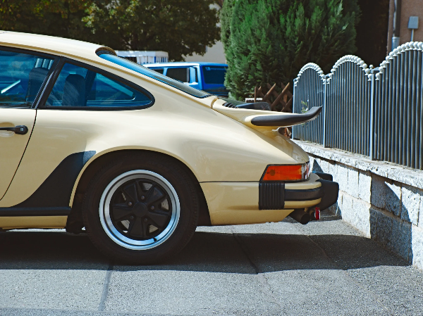 Cream Porsche 911 — rear quarter with spoiler