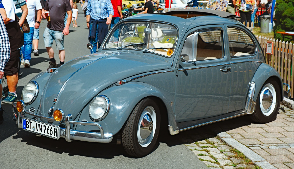 Grey Volkswagen Beetle along the festival street
